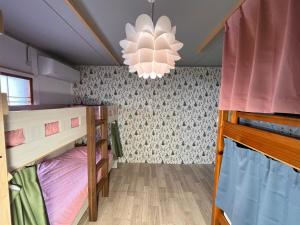 旭川TOTONOU Place的客房设有两张双层床和吊灯。