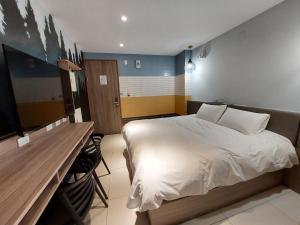 安平区安平商旅Choona Hotel Anping的一间卧室配有一张床和一张书桌