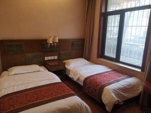 北京北京天坛惠庆园酒店的客房设有两张床和窗户。
