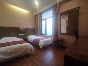 北京北京天坛惠庆园酒店的酒店客房设有两张床和窗户。