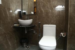 大诺伊达MK Regency的浴室配有白色卫生间和盥洗盆。