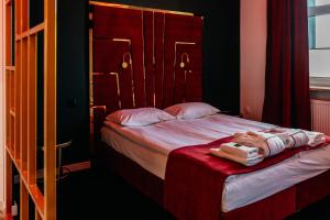 斯塔拉霍维采Hotel Senator Konferencje & SPA的一间卧室配有一张带木制床头板的床