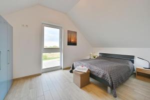 特伦特Villa Strandgut的一间卧室设有一张床和一个大窗户