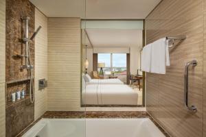 河内河内美利亚酒店的一间带浴缸的浴室和一张位于客房内的床