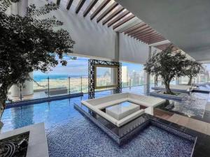迪拜Luxurious one bedroom Apartment的大楼内带桌子的大型游泳池