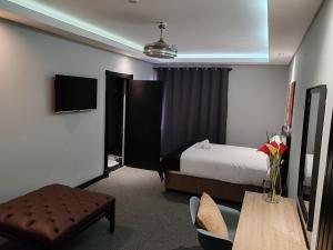 德班Durban Boutique Hotel的酒店客房配有一张床铺和一张桌子。