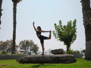 法里拉基埃斯佩罗斯宫度假酒店的一位在岩石上做瑜伽姿势的女人