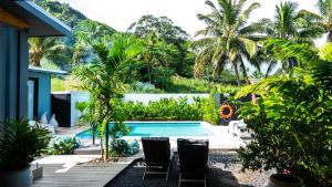拉罗汤加Casa Del Sol的一个带游泳池和棕榈树的后院