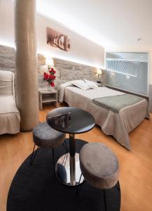 桑特朱丽亚德拉米斯赫罗纳帕劳酒店的一间卧室配有一张床、一张桌子和两张凳子