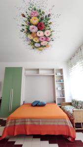 科尔萨诺L' Appoggio - Monolocale Eco-sostenibile A Due Passi Dal Centro Storico的一间设有一张床铺的客房,天花板上插着花卉