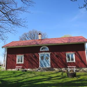 KumlaHuldas gård villa med självhushåll的红谷仓,有蓝色的门和窗户