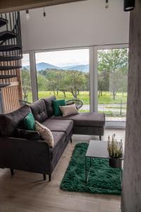 耶维克Beskid Sielski - klimatyczne domki w Lipowej z widokiem na góry i sauną - Dream Apart的客厅配有沙发和桌子
