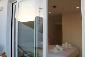 埃里塞拉Casa dos Cucos的一间设有镜子的客房,床上配有毛巾