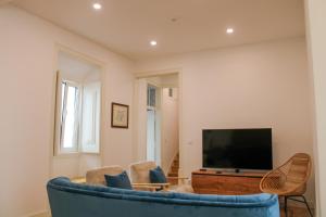 埃里塞拉Casa dos Cucos的客厅配有蓝色的沙发和电视