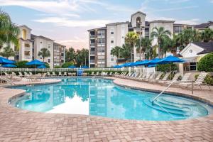 奥兰多Hilton Vacation Club Grande Villas Orlando的度假村的游泳池,配有椅子和遮阳伞