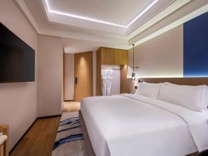上海上海静安诺富特酒店的一张大白色的床,位于酒店客房内