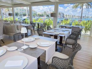 莫尔费塔DOGANA RESORT的一间设有桌椅并享有水景的餐厅