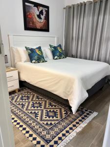 哈博罗内Sarona LoLa E206的一间卧室配有一张带地毯的大床