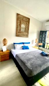 帕洛米诺HOTEL RENASCI PALOMINO的一间卧室配有一张带蓝色枕头的大床