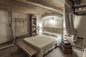 马泰拉伊尔滕波里托瓦多度假屋的一间卧室配有一张床,其中配有长凳