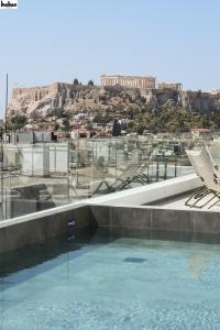 雅典NYX Esperia Palace Hotel Athens by Leonardo Hotels的享有雅典卫城景致的游泳池