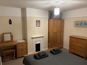 绍斯沃尔德Seastones的一间卧室配有一张床、一张桌子和一个壁炉
