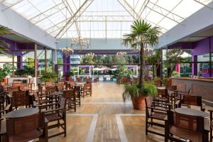 依克希亚迪俄尼索斯酒店的一个带桌椅的用餐大厅,棕榈树