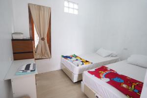 比哈尔Sapu Nyapah Losmen Syariah Tanjung Setia的小房间设有两张床和窗户