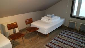 Borðeyri塔安加胡斯旅馆的带2把椅子和毛巾的床的房间