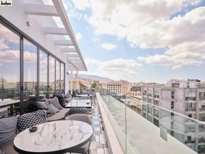 雅典NYX Esperia Palace Hotel Athens by Leonardo Hotels的设有带桌椅的市景阳台。