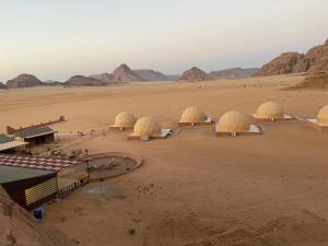 瓦迪拉姆Wadi Rum Aviva camp的一群在沙漠中的圆顶,有山