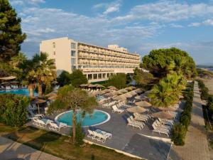卡斯特罗西基亚Ninos Grand Beach Resort的享有酒店空中美景,配有椅子和遮阳伞