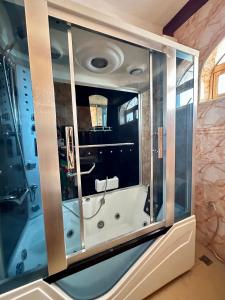 Kiembi SamakiAirport Lux Rooms的带浴缸和玻璃墙的浴室