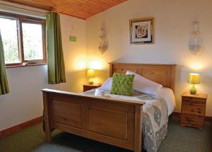彻克Brookside Leisure Park的一间卧室配有一张床、两盏灯和一个窗户。