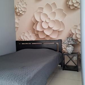 第聂伯罗Apartment on Tytova 8的卧室配有一张床,墙上挂着鲜花