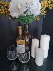 华沙Airport Apartment的一瓶葡萄酒和两杯酒及蜡烛