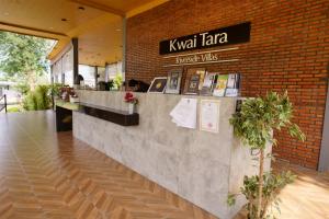 塞友Kwai Tara Riverside Villas的一间设有柜台和砖墙的餐厅