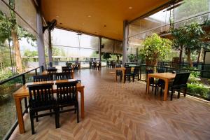 塞友Kwai Tara Riverside Villas的餐厅设有桌椅和大窗户。