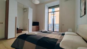 卡塔尼亚DUHOME apartment in the heart of Catania的一间卧室设有一张大床和一个大窗户