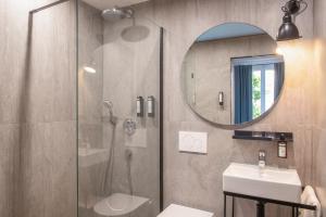 巴黎德拉波特多雷酒店的带淋浴、盥洗盆和镜子的浴室
