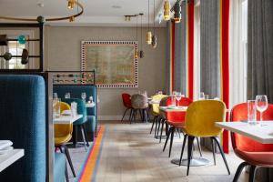 哈罗盖特罗丁公园酒店的餐厅设有红色和黄色的椅子和桌子