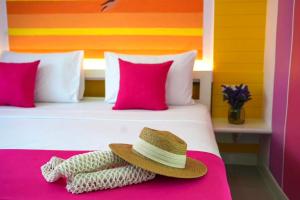 查汶LOVE beach club Koh Samui的床上的帽子和粉红色枕头