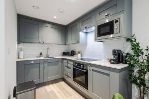 Stony MiddletonNo.44 - Deluxe 2-Bedroom Duplex with Balcony的厨房配有灰色橱柜和微波炉