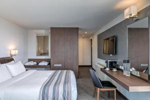 雅典斯坦利酒店的配有一张床和一张书桌的酒店客房