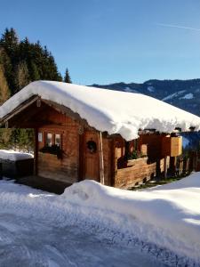 上柯尼希山麓米尔巴赫巴奇古特农家酒店的雪覆盖的小屋