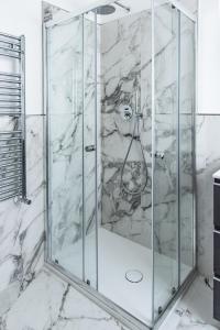 罗马Eur terrazzo vista Laghetto Modigliani的浴室里设有玻璃门淋浴