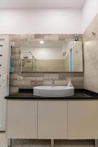 伏罗拉VILA LLANO的浴室设有白色水槽和镜子