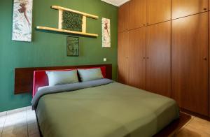 拉里萨GPX-CLR TheGreenFamilySuite的一间卧室设有一张床和绿色的墙壁