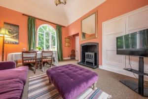 怀门德姆The Gate House的客厅配有紫色沙发和电视