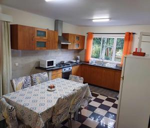蓬塔德尔加达Quinta das rãs的厨房配有桌椅和冰箱。